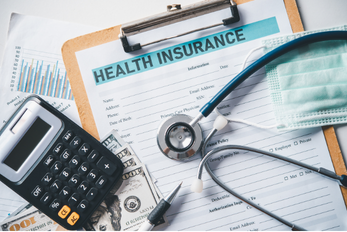 Health insurance form to receive insurance for a patient, money and calculator to calculate the fees, and a doctor's stethoscope